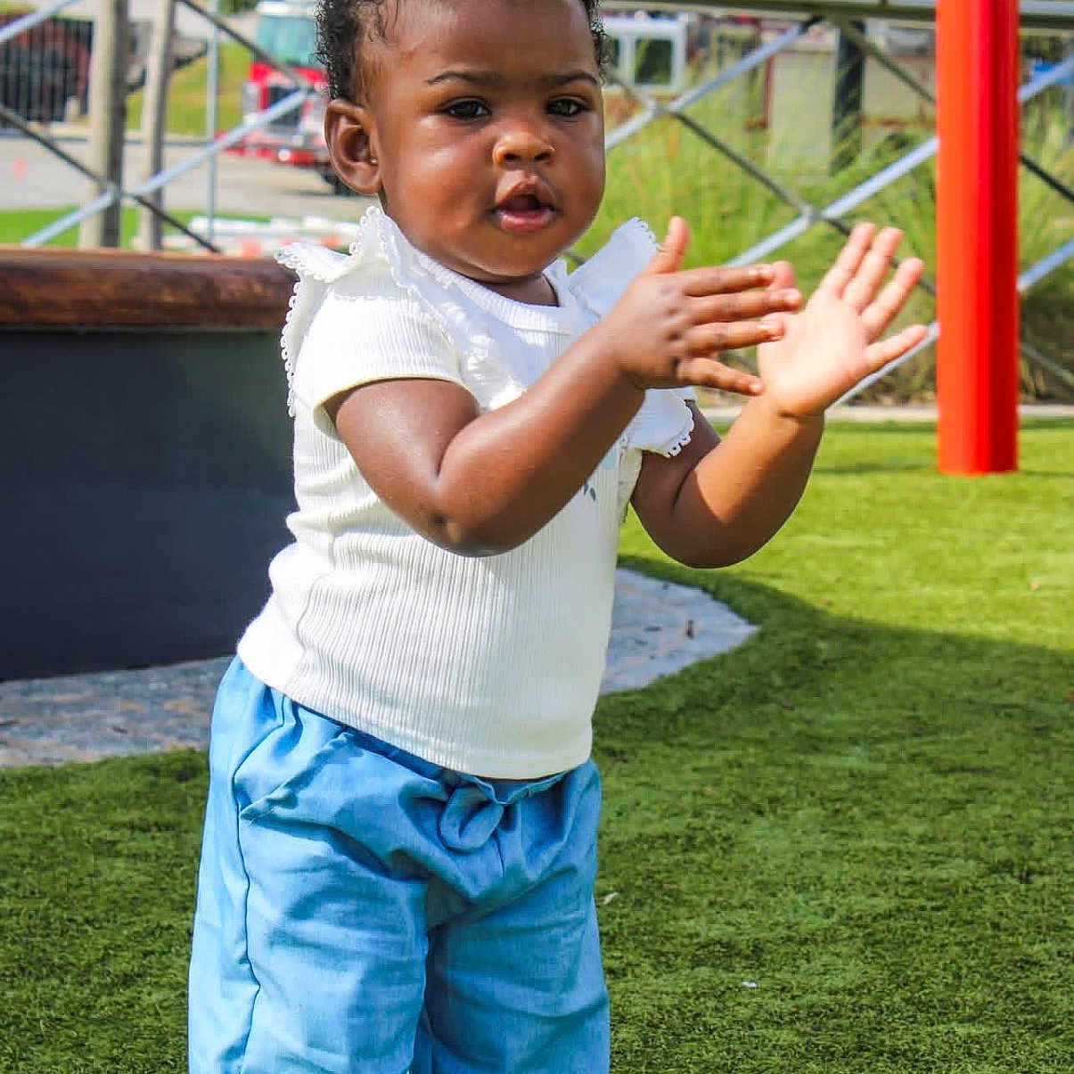 Rowyn joined the competition — help win amazing prizes! activity, blue_pants, casual_clothing, child, clapping, daylight, fun, grass, happy, nature, outdoor, park, person, play, playground, smile, summer, toddler, white_top, young_child