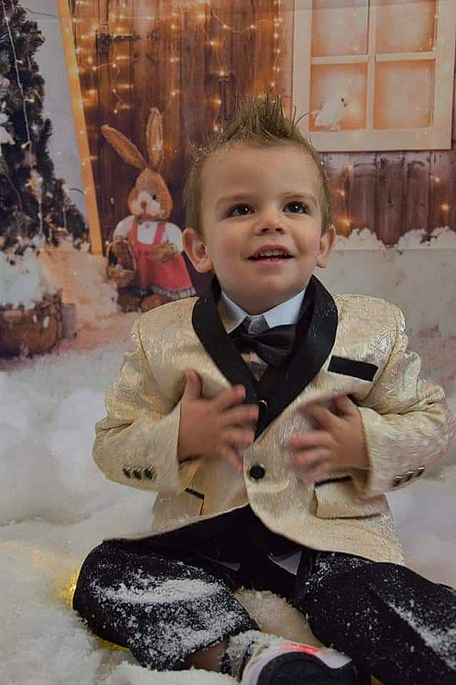 Julian a rejoint le concours — aidez-le/la à gagner de superbes lots ! baby, cheek, child, event, flooring, formal_wear, fun, fur, happy, head, joy, ornament, pattern, person, sitting, sleeve, smile, standing, toddler, tree