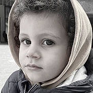 Yahel a rejoint le concours — aidez-le/la à gagner de superbes lots ! child, portrait, black_and_white, curly_hair, hood, jacket, face, expression, young, person, close_up, outdoor, candid, innocence, winter_clothing, eyes, young_child, soft_light, monochrome, serious