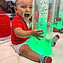 Oziel is registered to the contest to win money with this photo: baby, child, smiling, red_shirt, shorts, socks, indoor, bubble_tube, glowing_light, reflection, happy, playful, floor_mat, infant, cute, hand, sitting, bright_colors, joy, portrait
