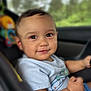 Oziel joined the competition — help win amazing prizes! baby, child, car_seat, smile, blue_shirt, shorts, toy, indoors, seatbelt, face, portrait, cute, happy, infant, person, young_child, chubby_arms, playful, window, car_interior