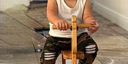 Oziel is registered to the contest to win money with this photo: toddler, child, smiling, wooden_toy, rocking_horse, indoor, floor, camo_pants, white_tank_top, barefoot, happy, playtime, toy, furniture, person, portrait, cute, young_child, hands, face