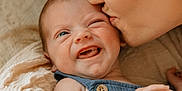 Maverick is registered to the contest to win money with this photo: baby, infant, mother, kiss, love, affection, closeup, face, skin, hand, clothing, blue_outfit, expression, emotion, parent, child, cute, tender, indoor, family
