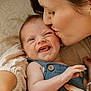 baby, infant, mother, kiss, love, affection, closeup, face, skin, hand, clothing, blue_outfit, expression, emotion, parent, child, cute, tender, indoor, family