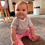 Iris joined the competition — help win amazing prizes! baby, child, smiling, striped_shirt, pink_pants, carpet, indoor, home, floor, sitting, cute, happy, person, face, small_hands, toes, furniture, kitchen, cabinet, cozy