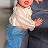 child, couch, curious, cute, fashion, floor, hair_bow, home, indoor, jeans, person, playful, portrait, smiling, sparkly_shoes, standing, striped_shirt, toddler, white_bow, young_child