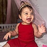 Emily joined the competition — help win amazing prizes! baby, toddler, crown, red_outfit, smiling, happy, sitting, indoor, child, cute, portrait, face, expression, clothing, headwear, infant, joyful, person, skin, hand