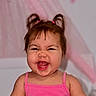 baby, background, child, closeup, cute, expression, face, funny_face, hair, happy, indoors, joyful, laughing, person, pigtails, pink_clothing, portrait, skin, smiling, toddler
