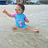 beach, child, cute, fun, outdoor, person, playful, reflection, sand, sitting, sky, summer, sunglasses, swimsuit, toddler, unicorn, urban, water, waterfront, waves