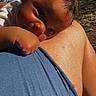 baby, child, shoulder, person, outdoor, sky, tree, blue_shirt, sunlight, skin, face, head, closeup, nature, daylight, relaxing, portrait, curious, calm, warm