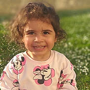 Elena participe au concours pour gagner de l'argent avec cette photo : casual_clothing, child, curly_hair, cute, daylight, flowers, garden, grass, greenery, happy, minnie_mouse, nature, outdoor, person, portrait, smiling, sunlight, sweater, toddler, young_child