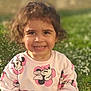 casual_clothing, child, curly_hair, cute, daylight, flowers, garden, grass, greenery, happy, minnie_mouse, nature, outdoor, person, portrait, smiling, sunlight, sweater, toddler, young_child