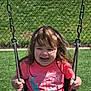 Brynnlee is registered to the contest to win money with this photo: child, swing, playground, grass, chain_link_fence, smiling, happy, outdoor, sunny, toddler, clothing, person, holding, play, fun, daylight, casual, joyful, young, portrait