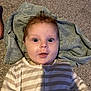 baby, infant, face, eyes, hair, towel, carpet, striped_clothing, onesie, floor, child, person, cute, expression, indoors, young_child, skin, portrait, lying_down, head