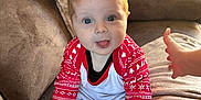 Kaleb joined the competition — help win amazing prizes! baby, blue_eyes, brown_furniture, child, couch, cozy, cute, hand, holiday_theme, home, indoor, infant, pajamas, plush, portrait, red_clothing, sitting, smiling, sofa, white_clothing
