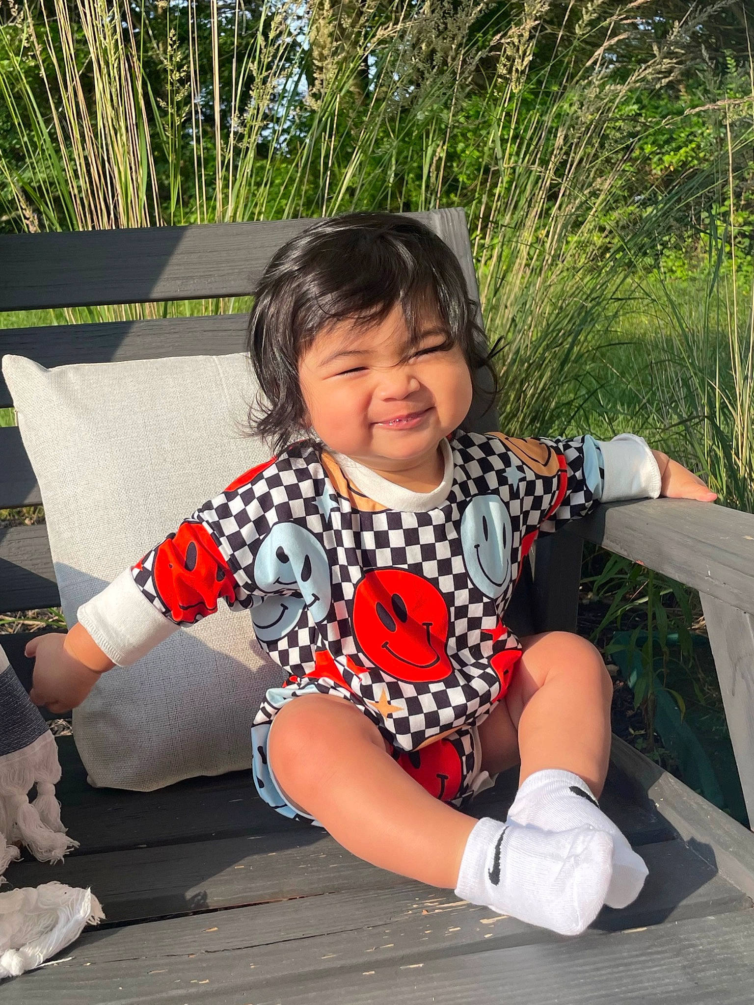 Liam is registered to the contest to win money with this photo: black_hair, child, cool, fun, grass, happy, human_leg, knee, lap, leg, leisure, pattern, person, plant, shoe, smile, sneakers, sock, thigh, toddler