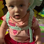 Zoey joined the competition — help win amazing prizes! baby, child, pink_shirt, red_shorts, harness, play_mat, toy, cushion, indoor, person, infant, sitting, curious, wide_eyes, open_mouth, colorful, floor, young_child, casual_clothing, baby_toys