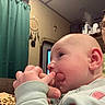 Noah is registered to the contest to win money with this photo: baby, infant, adult, face, portrait, selfie, indoors, sitting, curious, chewing, hand, fingers, glasses, green_sweater, clothing, blanket, curtains, living_room, shelf, home