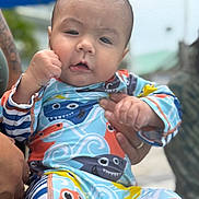 Mateo joined the competition — help win amazing prizes! baby, child, infant, person, face, hand, clothing, colorful, pattern, shark, outdoor, blurred_background, holding, cute, expression, fist, young, skin, portrait, sleeves