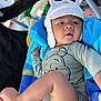 Mateo is registered to the contest to win money with this photo: baby, child, infant, hat, onesie, stroller, blanket, towel, blue, orange, face, foot, hand, clothing, cute, outdoor, portrait, relaxed, person, babywearing
