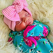 Delilah joined the competition — help win amazing prizes! newborn, baby, sleeping, pink_bow, hat, floral_outfit, blue_clothing, fluffy_blanket, cozy, cute, infant, portrait, closeup, soft_texture, peaceful, child, resting, headwear, patterned_clothing, adorable