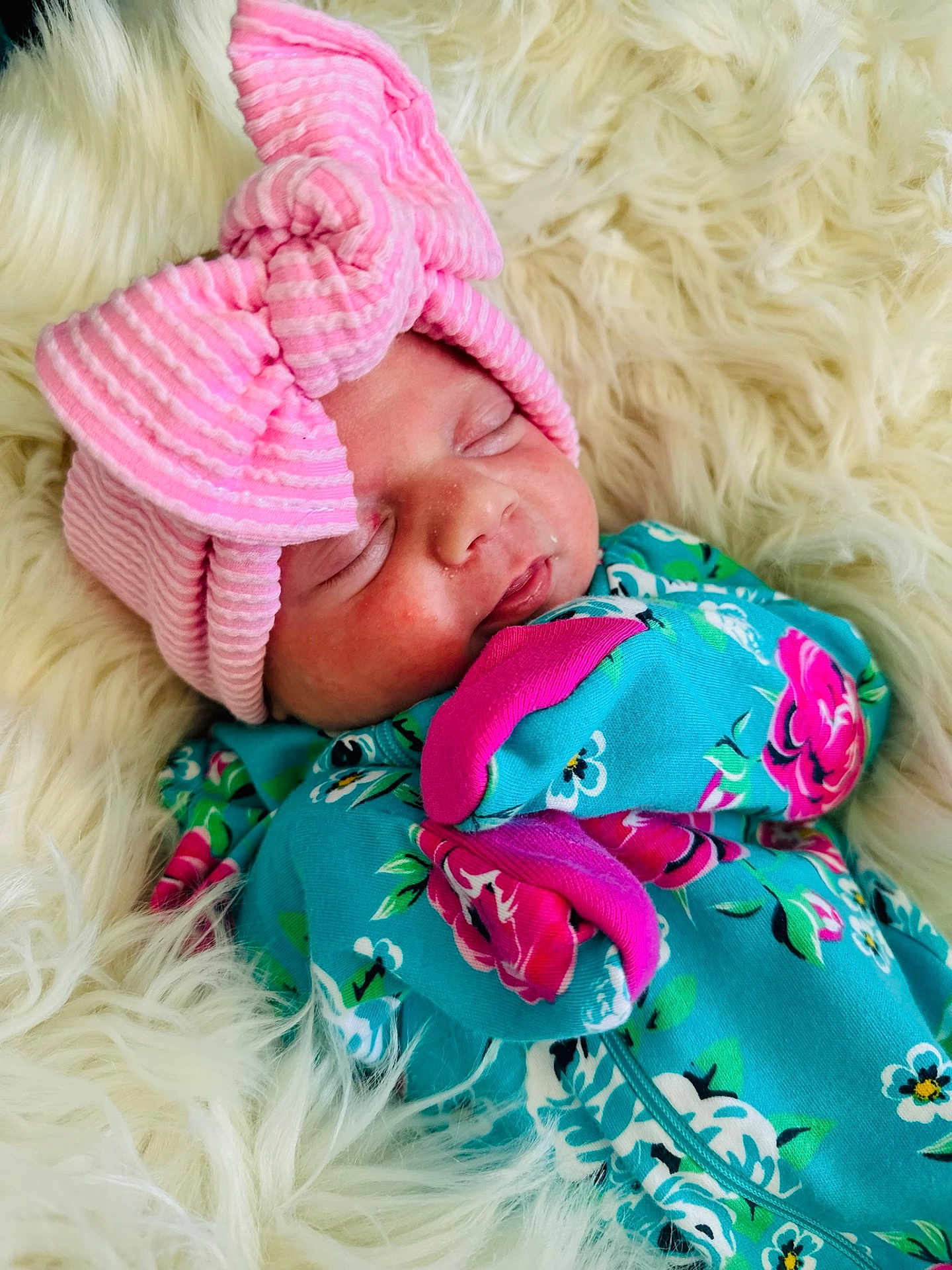 Delilah joined the competition — help win amazing prizes! newborn, baby, sleeping, pink_bow, hat, floral_outfit, blue_clothing, fluffy_blanket, cozy, cute, infant, portrait, closeup, soft_texture, peaceful, child, resting, headwear, patterned_clothing, adorable