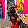 child, cat, black_cat, red_dress, indoor, art, painting, pink_wall, carpet, bench, smile, holding, pet, happy, person, home_decor, furniture, portrait, cute, animal