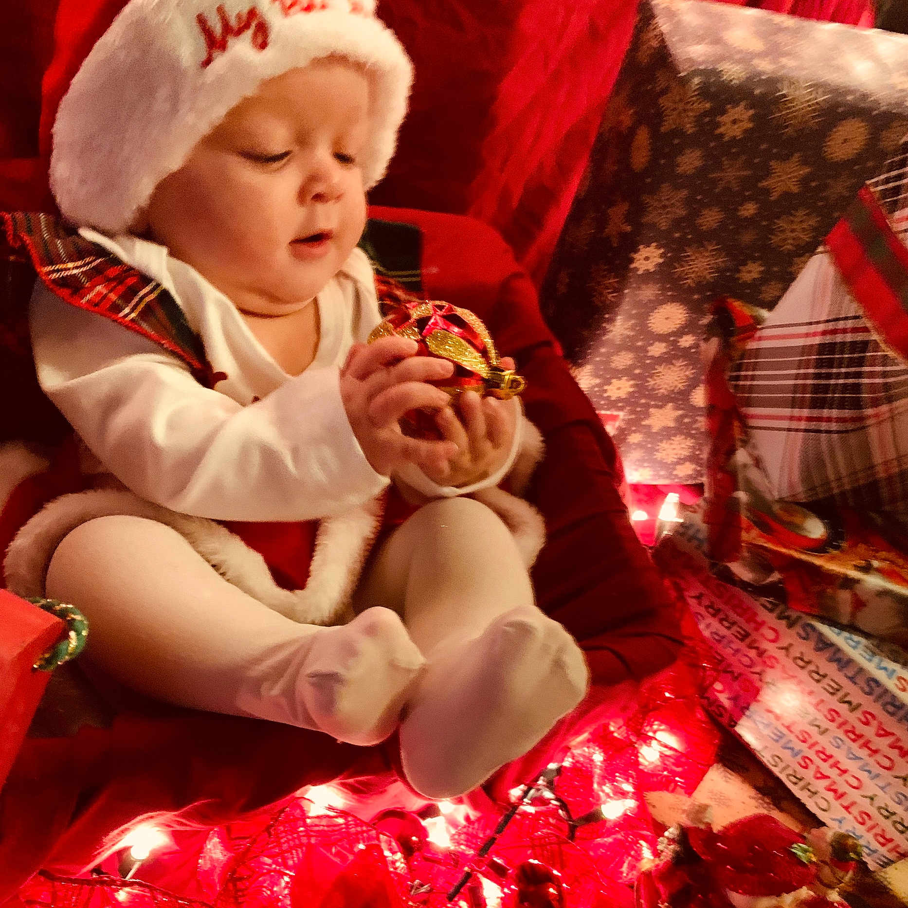 Jaina Willow joined the competition — help win amazing prizes! baby, celebration, child, christmas, cute, festive, gift, hat, holiday, holiday_decor, indoor, lights, ornament, person, red, seasonal, smiling, tights, white, wrapped_presents