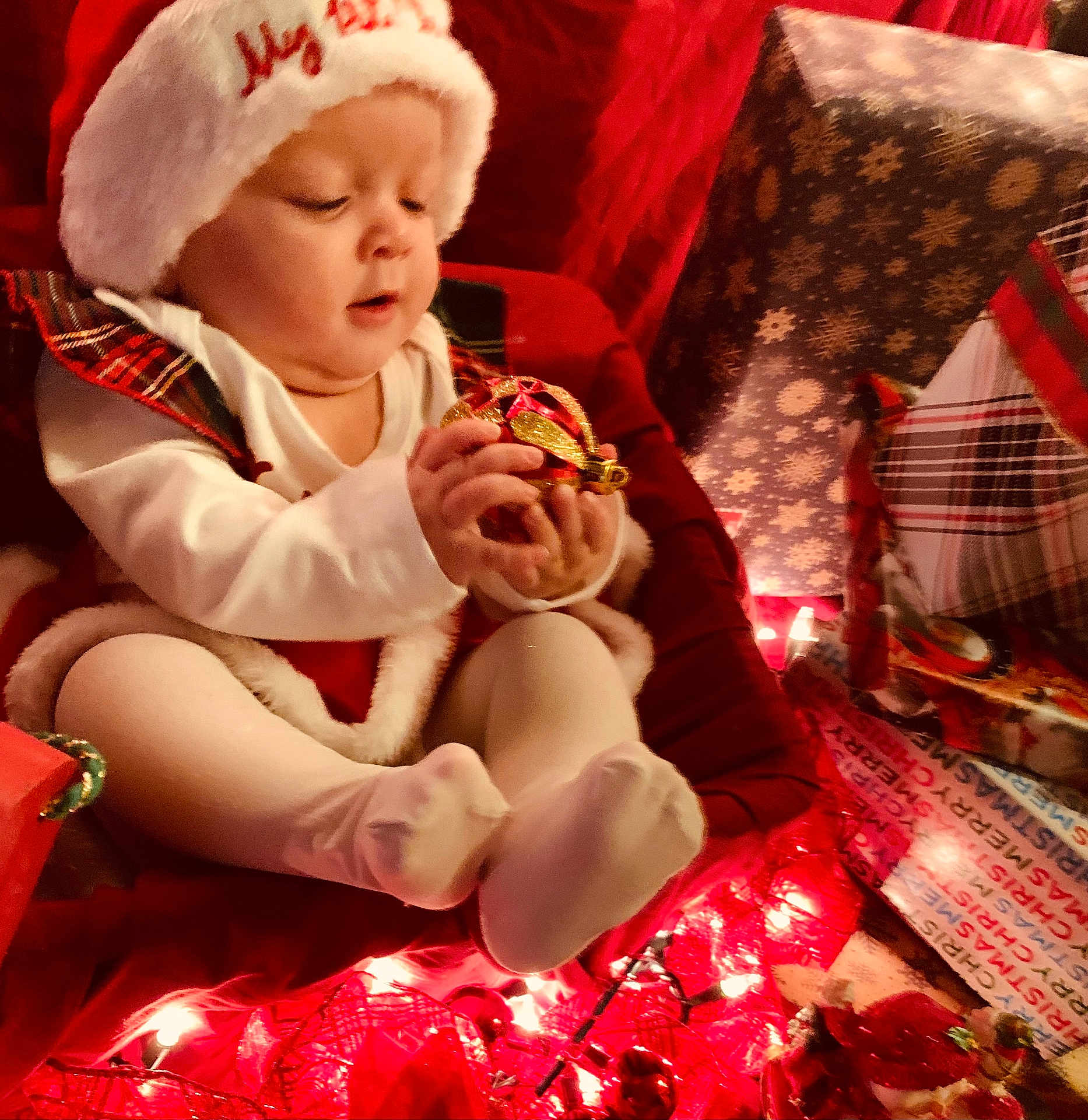 Jaina Willow joined the competition — help win amazing prizes! baby, child, holiday, christmas, ornament, lights, gift, wrapped_presents, red, white, hat, tights, festive, celebration, indoor, cute, holiday_decor, smiling, seasonal, person