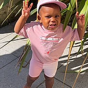 Loisse a rejoint le concours — aidez-le/la à gagner de superbes lots ! barefoot, cap, casual, child, concrete, gesture, greenery, happy, nike, outdoor, person, pink_clothing, plants, playful, shadow, sidewalk, smiling, sunlight, toddler, young_child