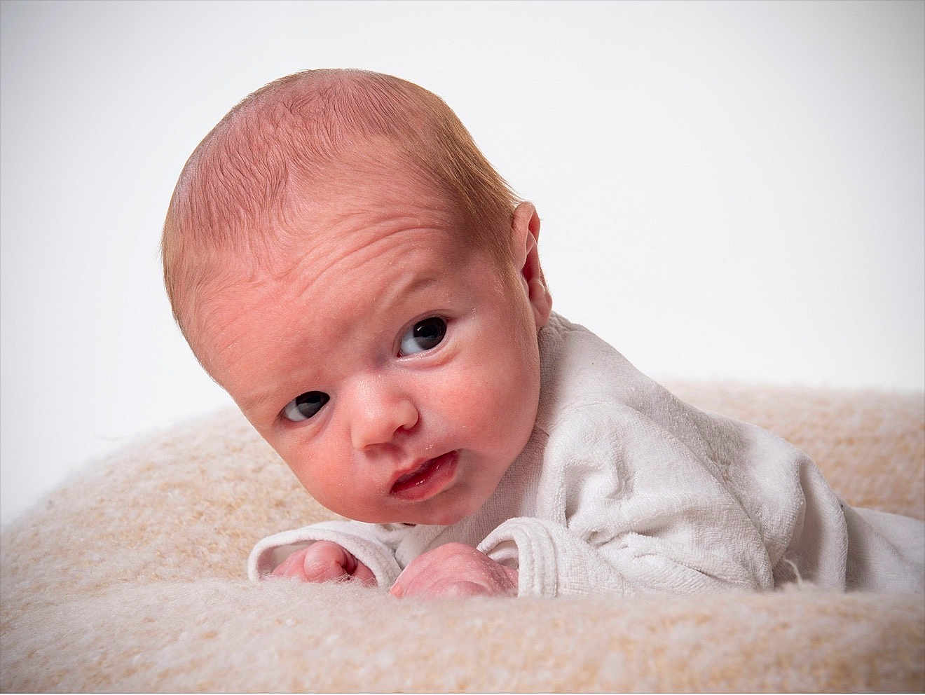 Eden a rejoint le concours — aidez-le/la à gagner de superbes lots ! baby, newborn, infant, portrait, face, blanket, studio_photography, closeup, lying_down, white_background, curious, eyes, skin, head, small_hands, cozy, expression, soft_texture, looking_sideways, clothing