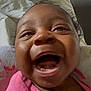 baby, infant, smiling, laughing, close_up, face, pink_clothing, blanket, cozy, indoors, joyful, happy, cute, child, person, head, expression, skin, mouth_open, teeth