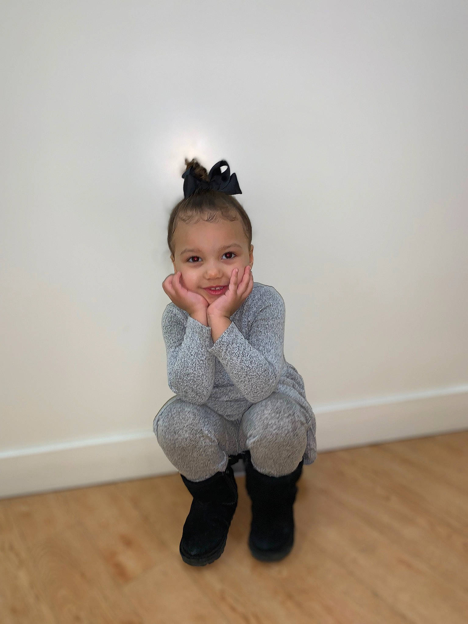Melani is registered to the contest to win money with this photo: baby_toddler_clothing, face, fashion_accessory, floor, flooring, fur, happy, hardwood, human_leg, joy, knee, laminate_flooring, leg, pattern, person, sitting, sleeve, smile, sock, toddler