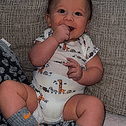 Gatlin is registered to the contest to win money with this photo: baby, bodypart, chair, clothing, couch, cushion, face, finger, furniture, glove, hand, head, homedecor, hosiery, person, photography, portrait, shorts, sitting, sock