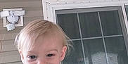 Tanner is registered to the contest to win money with this photo: blonde_hair, blue_shirt, casual_clothing, child, cute, daylight, face, happy, house, outdoor, person, playful, porch, portrait, railing, sliding_door, smiling, toddler, window, young_child