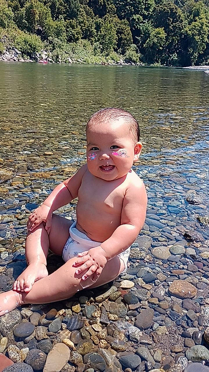 Angelica is registered to the contest to win money with this photo: baby, chest, flash_photography, foot, fun, grass, happy, human_body, human_leg, lake, leisure, people_in_nature, person, plant, smile, summer, thigh, toddler, tree, water