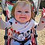 Gracelyn is registered to the contest to win money with this photo: arm, baby, child, clothing, cute, fabric, face, hair, happy, mickey_mouse, minnie_mouse, nature, outdoor, person, playful, seatbelt, smiling, stroller, sunlight, toddler