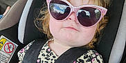 Gracelyn is registered to the contest to win money with this photo: car_interior, car_seat, child, cracked_windshield, cute, expression, face, fashion, hair, hello_kitty, indoors, leopard_print, pink, portrait, safety_harness, seat, seatbelt, sunglasses, toddler, young_child