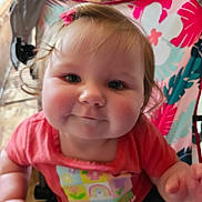 Gracelyn joined the competition — help win amazing prizes! baby, cheeks, child, close_up, colorful_shirt, curious, cute, face, flowers, hair, happy, indoor, infant, person, pink_bow, rainbow, seated, smile, stroller, young