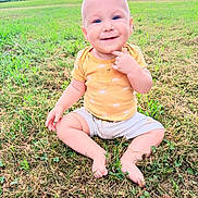 Bjorn is registered to the contest to win money with this photo: baby, child, grass, outdoor, smile, yellow_shirt, shorts, barefoot, greenery, field, nature, happy, portrait, sitting, summer, sun_pattern, cute, one_person, daylight, sky