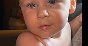 Bjorn is registered to the contest to win money with this photo: baby, child, face, blue_eyes, hair, mohawk, skin, arm, diaper, indoor, lighting, portrait, curious, expression, closeup, infant, person, cute, soft_light, background