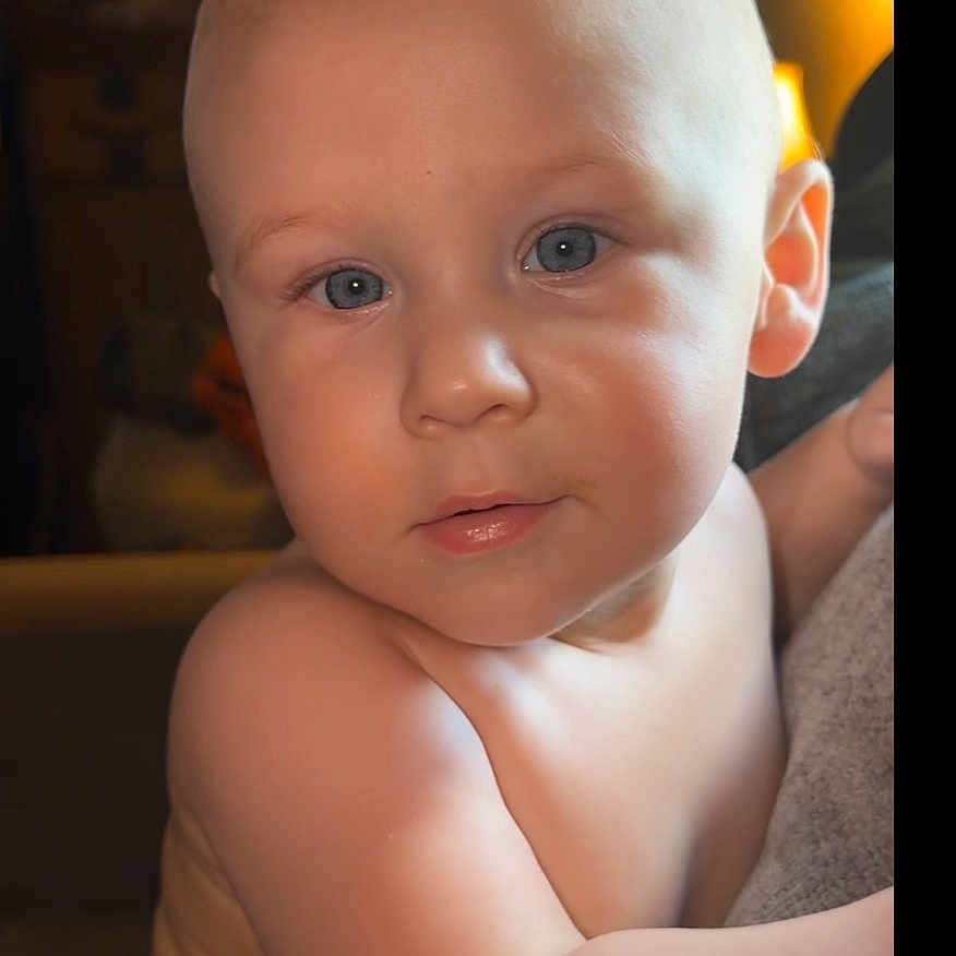 Bjorn is registered to the contest to win money with this photo: baby, child, face, blue_eyes, hair, mohawk, skin, arm, diaper, indoor, lighting, portrait, curious, expression, closeup, infant, person, cute, soft_light, background