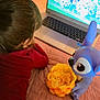 child, bed, blanket, laptop, animation, toy, popcorn, doll, pink, purple, red_clothing, hair, indoor, screen, cartoon, entertainment, relaxation, bedroom, soft_toy, cushion