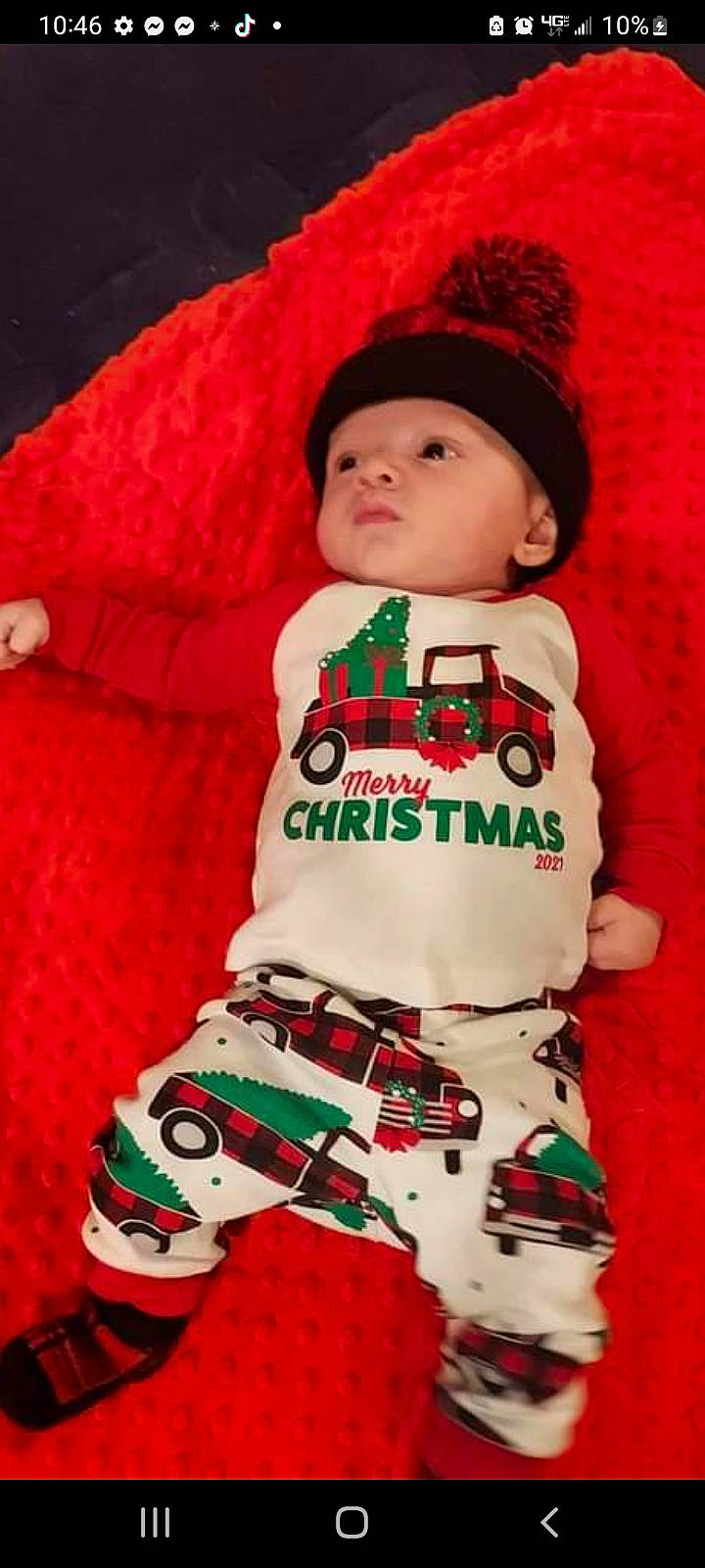 Logan joined the competition — help win amazing prizes! baby, baby_toddler_clothing, cap, carmine, child, christmas, christmas_eve, costume, event, face, facial_expression, fictional_character, headwear, holiday, pattern, person, red, sleeve, sock, standing