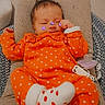 Inaya a rejoint le concours — aidez-le/la à gagner de superbes lots ! adorable, baby, child, cozy, cushion, cute, heart_pattern, indoors, infant, newborn, orange_outfit, pacifier, peaceful, purple_butterfly_stickers, red_dots, relaxing, resting, sleeping, soft_texture, white_socks