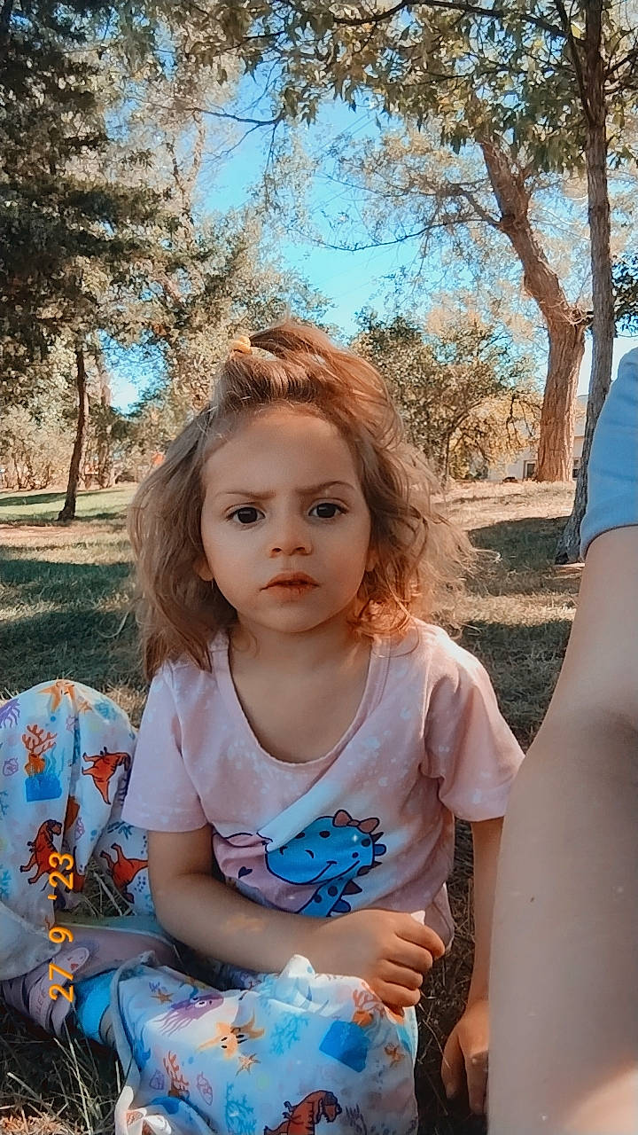 Hazel joined the competition — help win amazing prizes! blond, blue, child, daytime, electric_blue, facial_expression, fun, grass, happy, iris, leaf, leisure, people_in_nature, person, plant, recreation, sitting, sky, sunlight, toddler