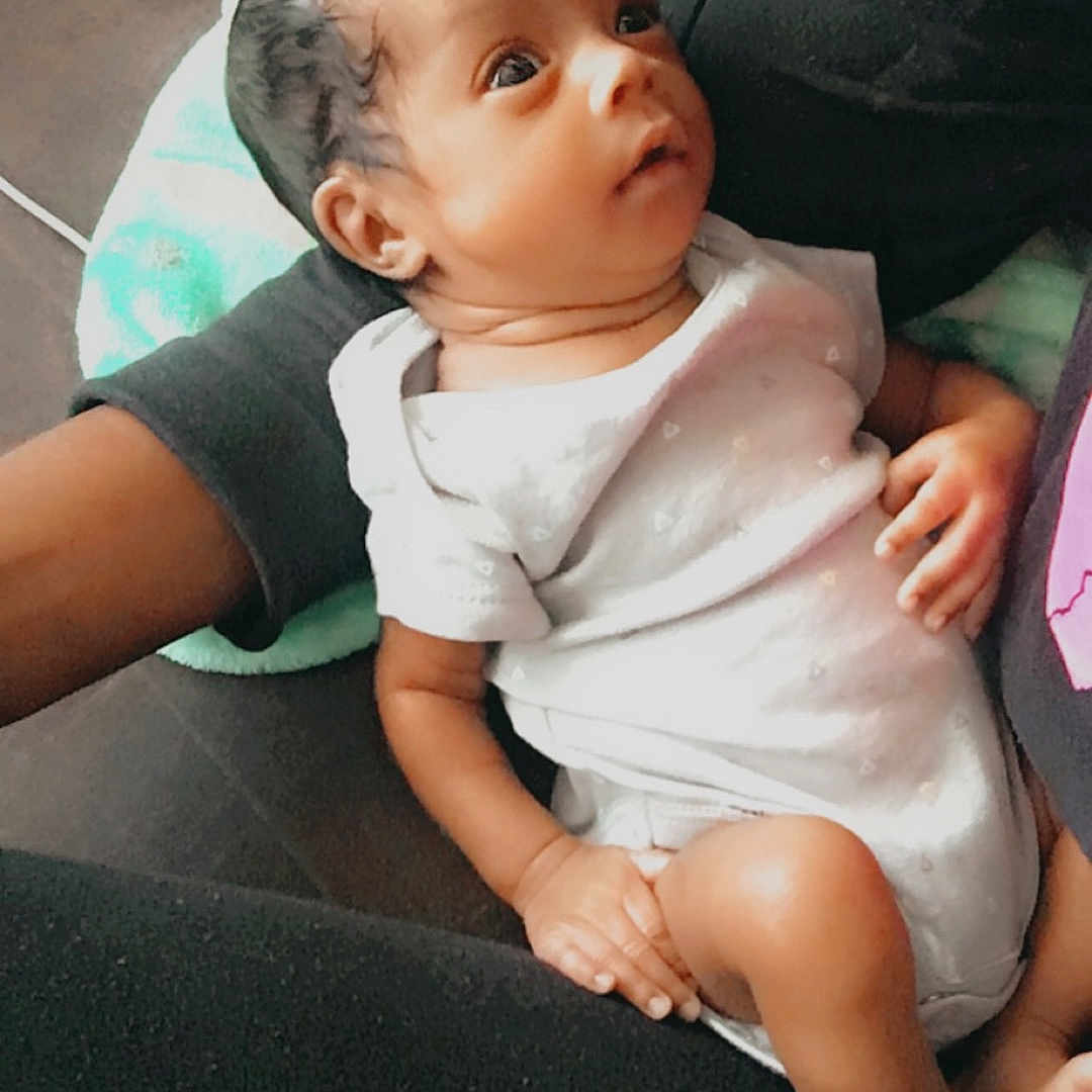 Ardarius joined the competition — help win amazing prizes! arm, baby, blanket, casual_clothing, child, closeup, comfort, couch, curly_hair, face, gaze, hand, indoor, infant, leg, onesie, person, resting, skin, soft_texture