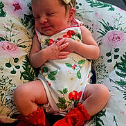 Aria-Jade is registered to the contest to win money with this photo: baby, sleeping, infant, onesie, headband, bow, red_booties, cushion, floral_pattern, peaceful, cute, hands, legs, indoors, soft_lighting, newborn, person, portrait, resting, cozy