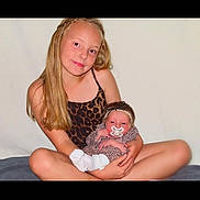 Ivy-rose Beulah is registered to the contest to win money with this photo: child, baby, sibling, leopard_print, pacifier, headband, long_hair, blonde, holding, smiling, sitting, indoor, cute, family, portrait, infant, young, girl, toddler, comfort