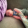 Michael is registered to the contest to win money with this photo: toddler, sleeping, couch, pillow, quilt, blanket, child, indoor, rest, peaceful, cozy, nap, furniture, soft, comfort, relaxation, young_child, home, portrait, casual_clothing